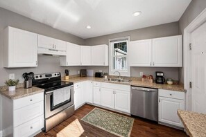 Enjoy cooking in this well-equipped kitchen with an oven, range hood, and stainless steel dishwasher.