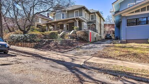 A two-story house with a front porch, a staircase leading to the second floor, and a driveway. - Bright Apartment 3 Mi to Downtown Birmingham! (Birmingham)