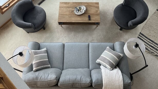 A living room with a fireplace, two armchairs, a sofa, and a coffee table.