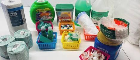 A variety of cleaning supplies including paper towels, dish soap, and laundry detergent.