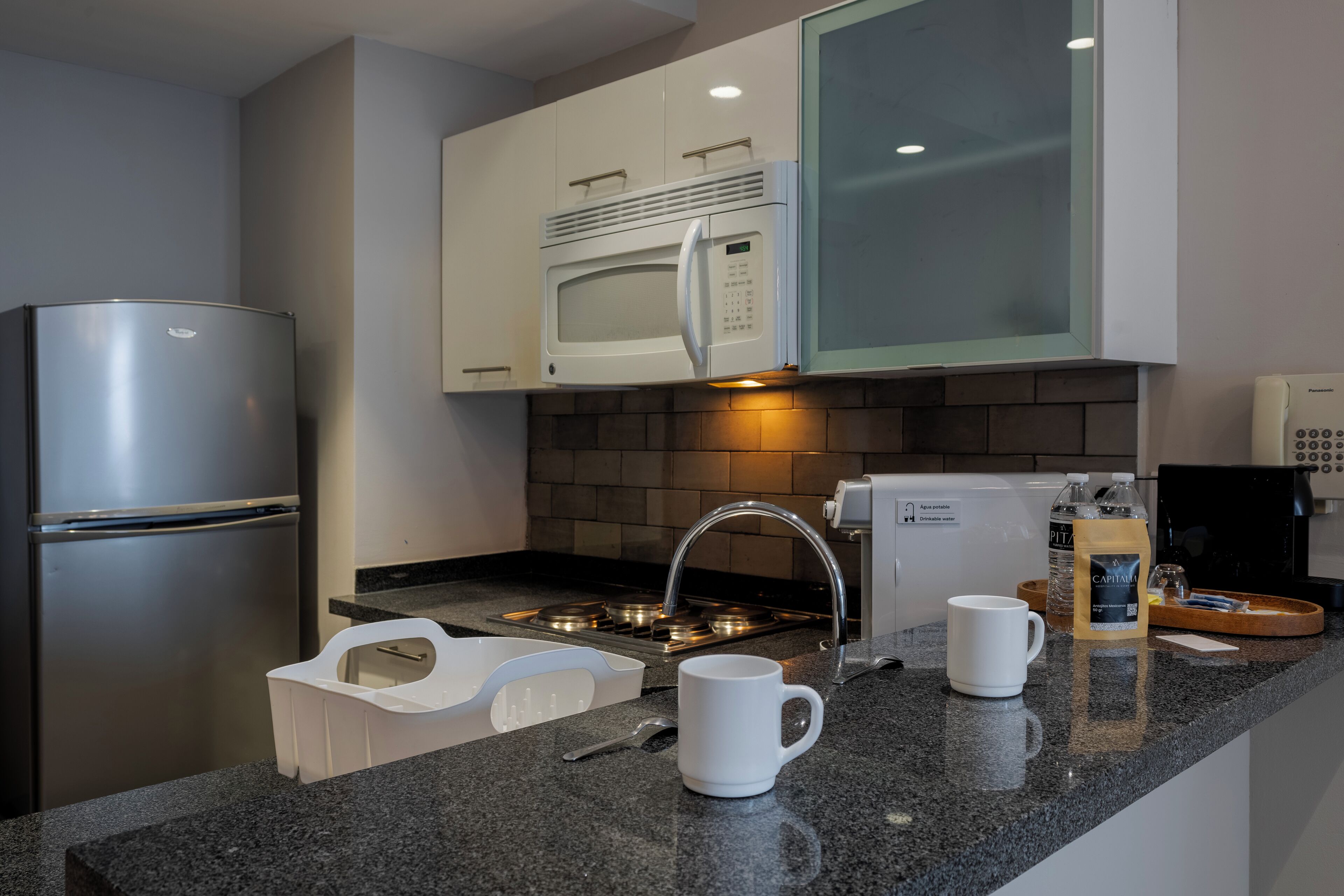 A modern kitchen with stainless steel appliances, a microwave, a coffee maker, and a toaster.