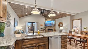 A spacious kitchen with granite countertops, wooden cabinets, and a built-in dishwasher. - Luxury Lodge w/ Hot Tub + Boat Slip | 2 Min to Silver Dollar City! (Branson)