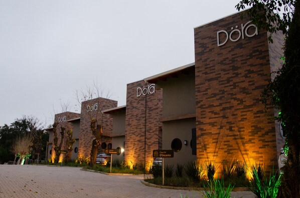 Un bâtiment orné de nombreux panneaux indiquant le nom « Dola », ce qui suggère qu’il s’agit d’un hôtel ou d’un complexe touristique.