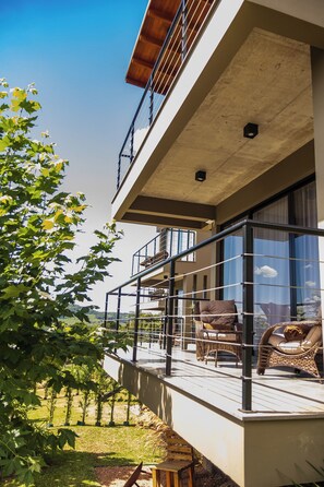 Un bâtiment moderne doté d’un balcon, d’un espace extérieur aménagé et offrant une vue sur le paysage environnant.