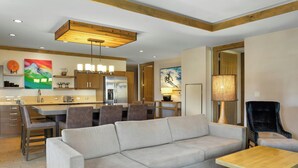 A modern living room with a sofa, a coffee table, and a dining area with chairs and a table. - Club Wyndham Resort at Avon (Avon)