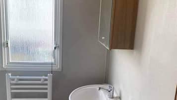 A bathroom with a white sink, a mirror, and a wooden cabinet.