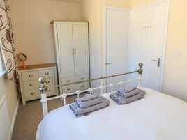 Un dormitorio con cama, armario, espejo y puerta.