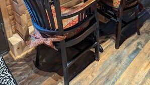 A cozy wooden cabin with a round table and two chairs, a framed picture on the wall, and a small shelf with board games. - Studio Cabin, minutes from lake and trails (North Bend)
