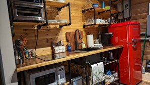 A compact kitchen with a built-in oven, microwave, and red refrigerator. - Studio Cabin, minutes from lake and trails (North Bend)