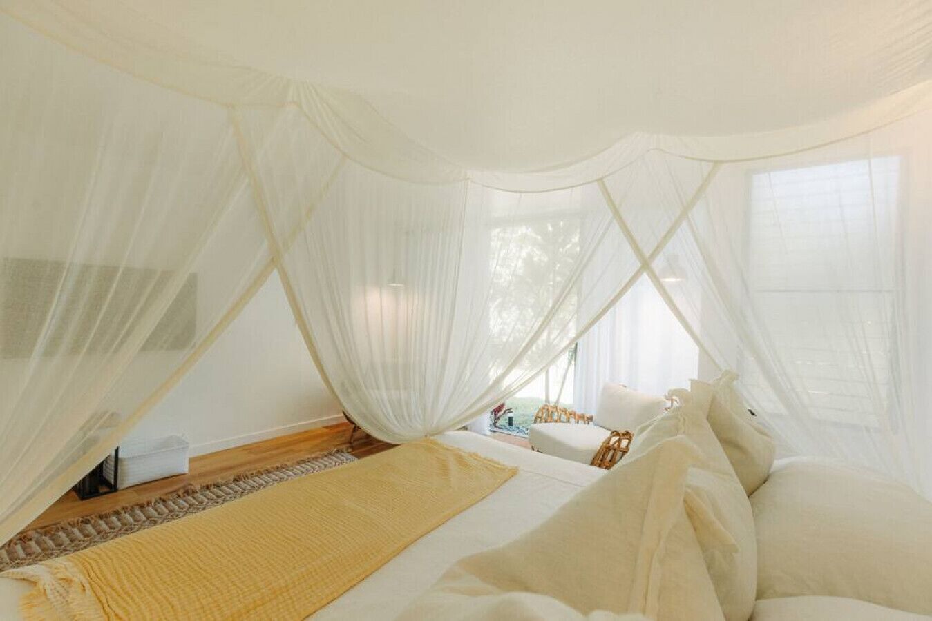 A room with a bed, a window, and a view of the outdoors.