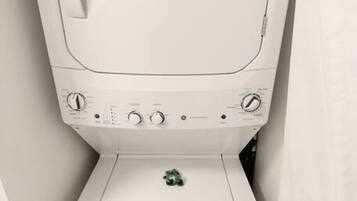 A compact, white, wall-mounted washing machine with a control panel and a small drawer below.