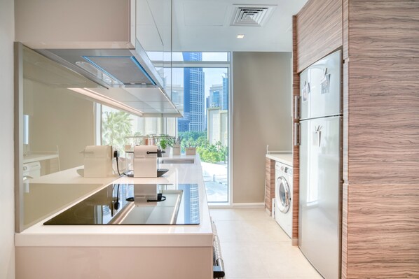 A modern kitchen with a large island, built-in appliances, and a view of the city.