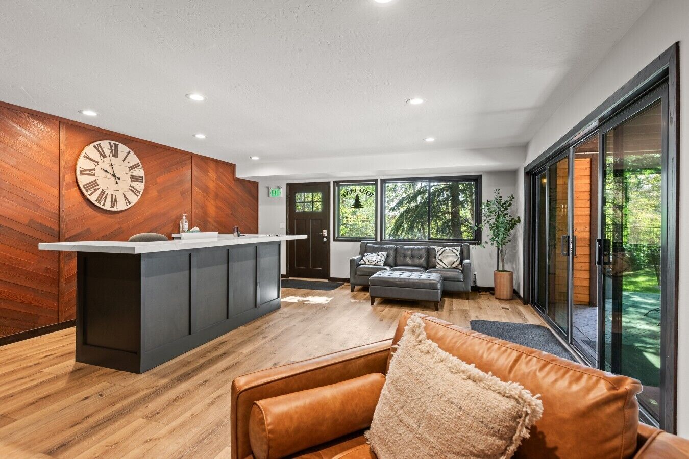 A modern interior with a reception desk, a sofa, and a large window.