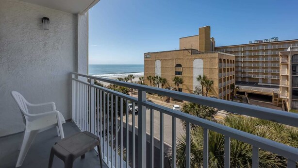 Ein Balkon mit Blick auf Strand und Häuser.