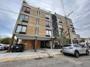 Un immeuble à plusieurs étages, doté d’une architecture moderne, avec des balcons et de grandes fenêtres.