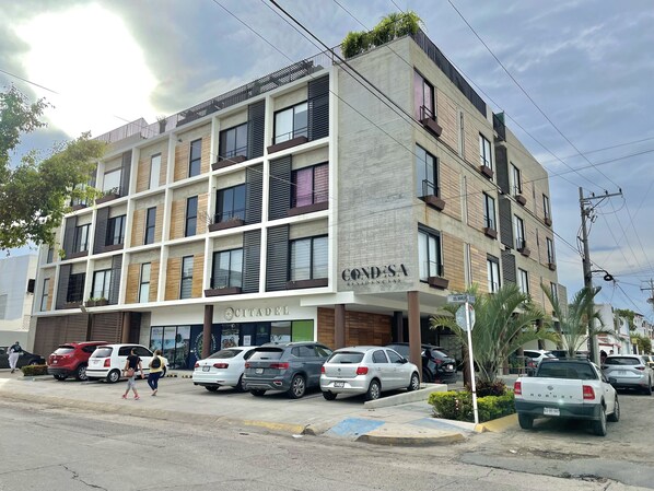 Un immeuble à plusieurs étages doté d’une architecture moderne, avec des balcons et une variété de styles de fenêtres.
