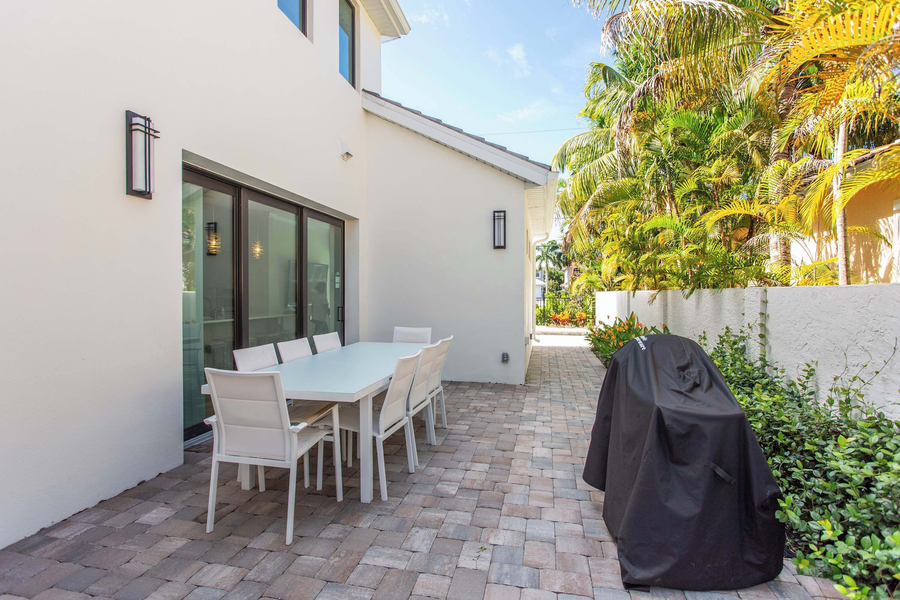 Outdoor dining and grilling area with entrance to the main house and cabana