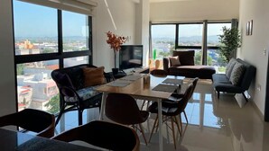 Uma sala de estar moderna com área de jantar, janelas amplas e ventilador de teto.