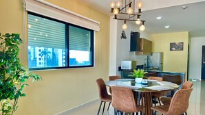 Uma sala de jantar moderna com uma mesa redonda, seis cadeiras e um vaso de planta.