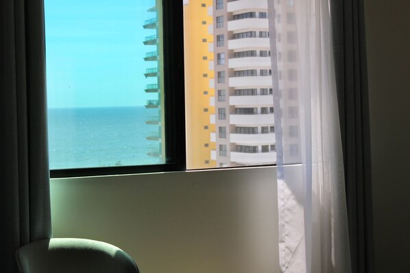 Una ventana con vista al mar y un rascacielos.