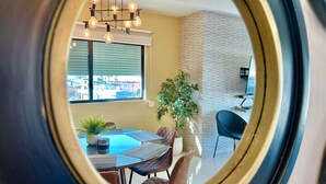 Uma área de jantar com uma mesa redonda, cadeiras e um lustre.