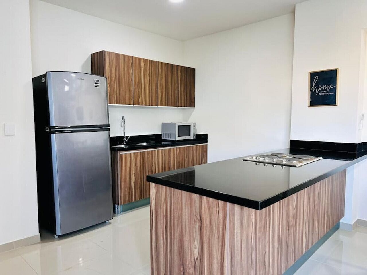 A modern kitchen with a built-in island, stainless steel appliances, and wooden cabinetry.