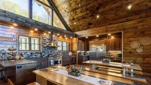 Une cuisine spacieuse dotée de meubles en bois, d’un grand îlot central et d’un coin repas avec des bancs.