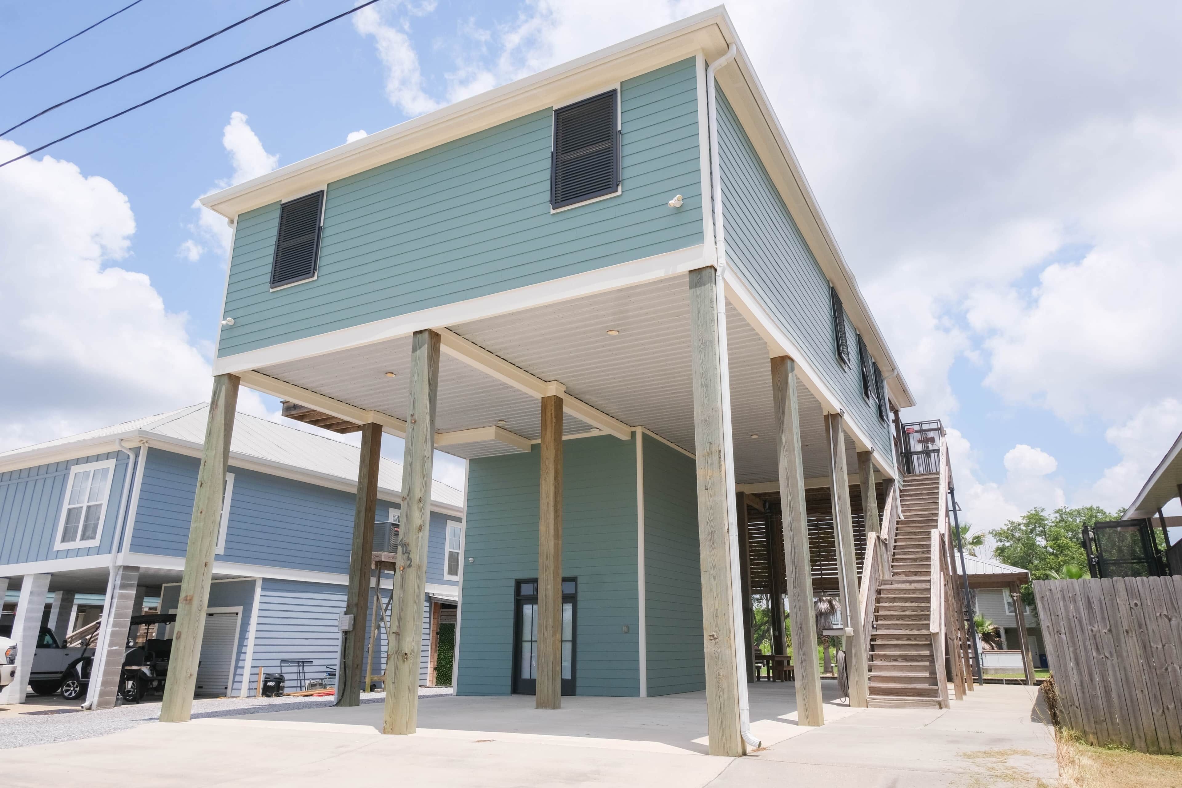 A two-story house with a covered porch and a staircase leading to the upper floor.