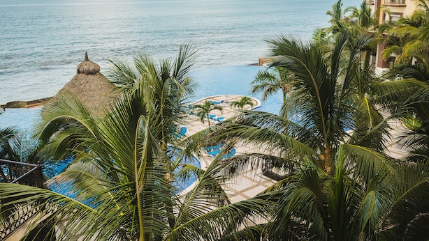 A resort with a pool, palm trees, and a view of the ocean. - Gavias Grand Ocean Front (Mazatlán)