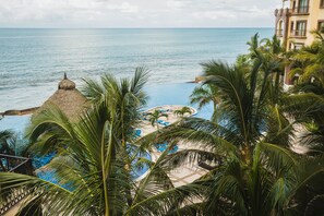 A resort with a pool, palm trees, and a view of the ocean. - Gavias Grand Ocean Front (Mazatlán)