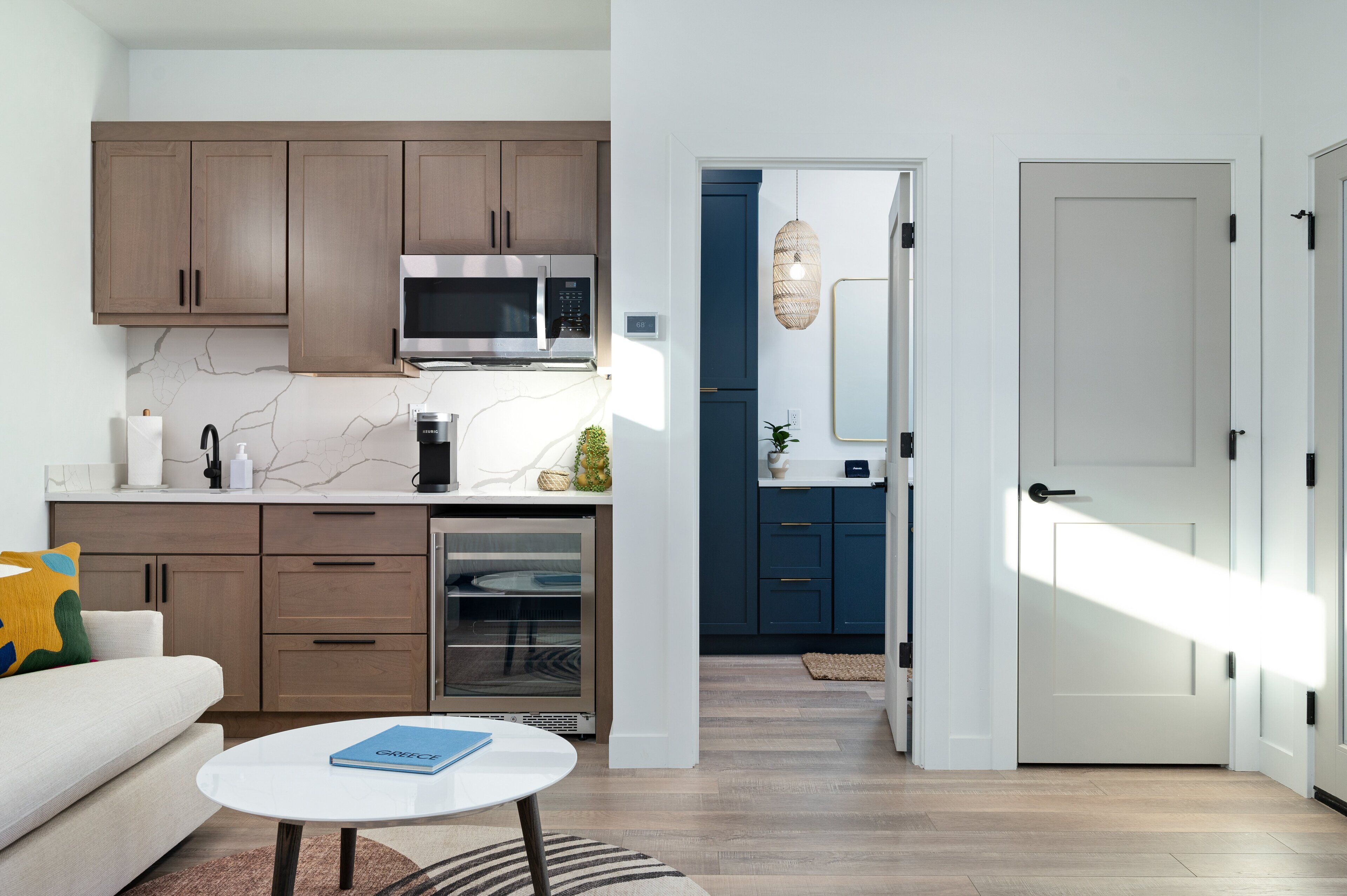 A modern kitchen with wooden cabinets, a built-in microwave, and a stainless steel oven.