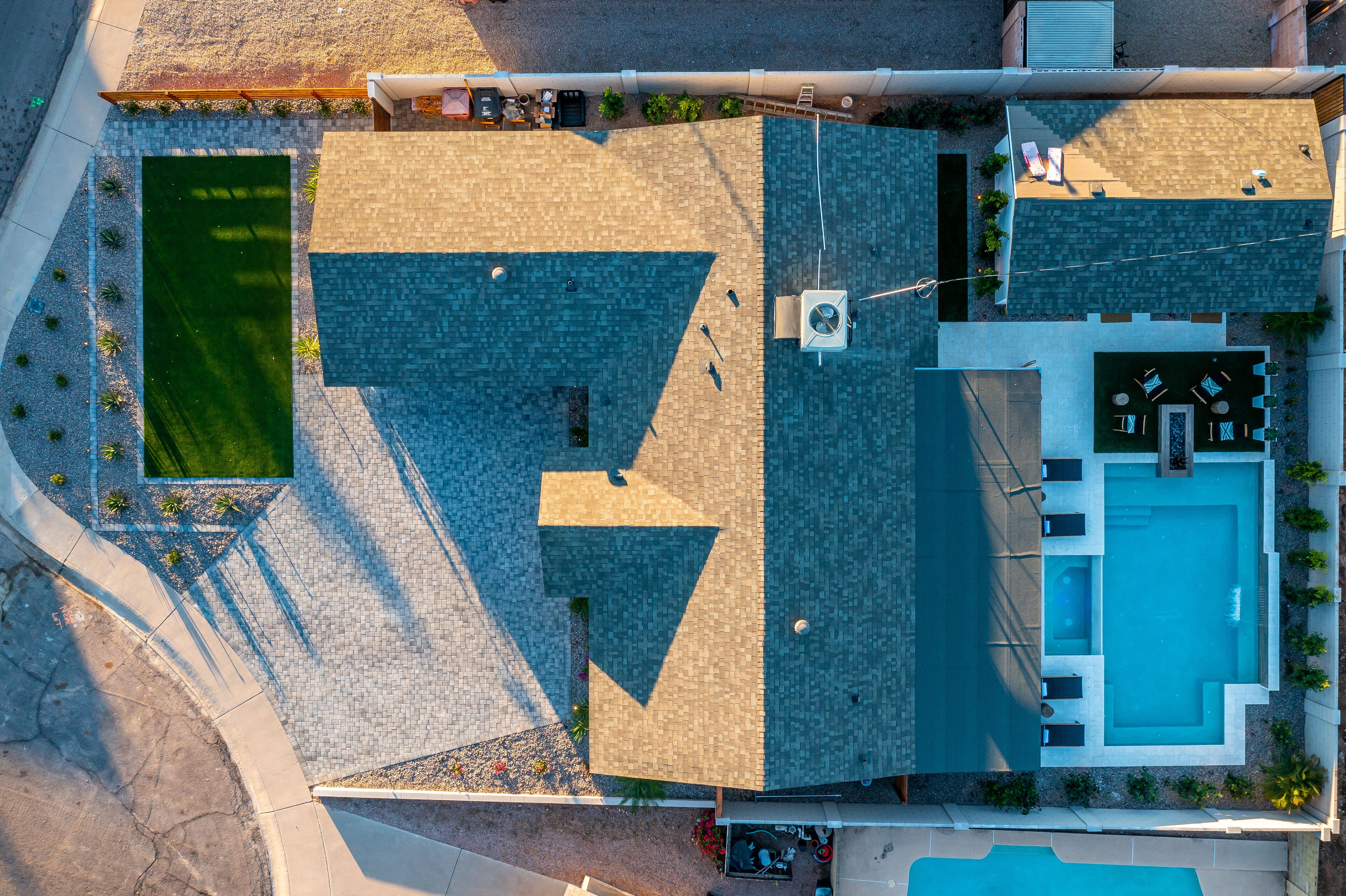 Vue aérienne d’une propriété dotée d’une piscine, d’un espace patio et d’un jardin aménagé.