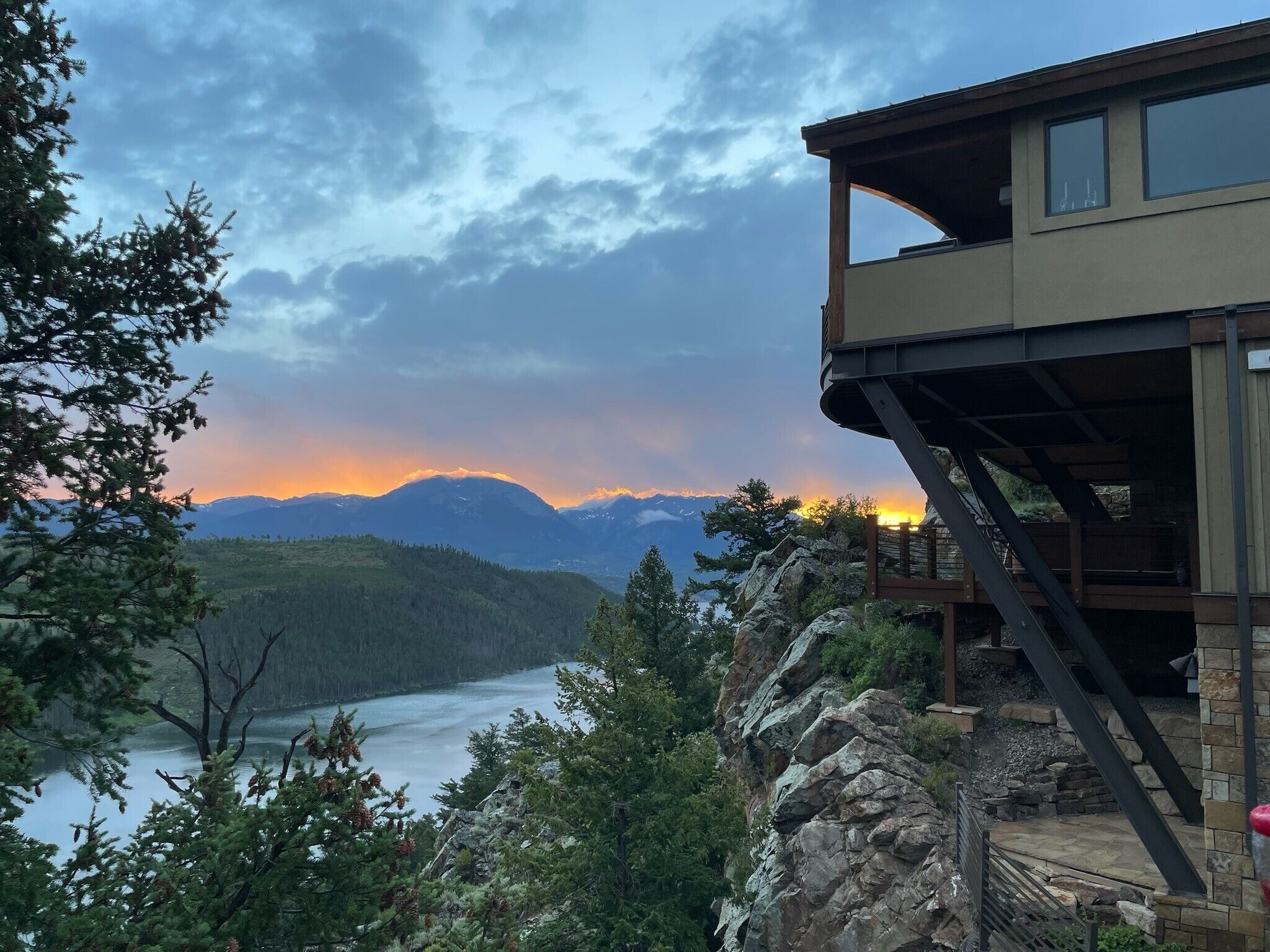 Una cabaña de montaña con vista a un lago y montañas.