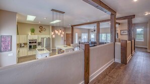 Une cuisine spacieuse équipée d’appareils électroménagers modernes, un coin repas et un salon doté d’une grande fenêtre.