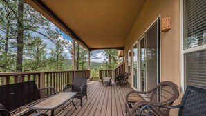 Une terrasse en bois avec des meubles en osier et un espace abrité.