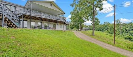 A two-story house with a covered porch and a staircase leading to the upper level.