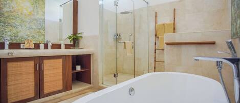 Une salle de bain moderne dotée d’une douche à parois de verre, d’une baignoire sur pieds et d’un meuble-lavabo en bois avec un grand miroir.