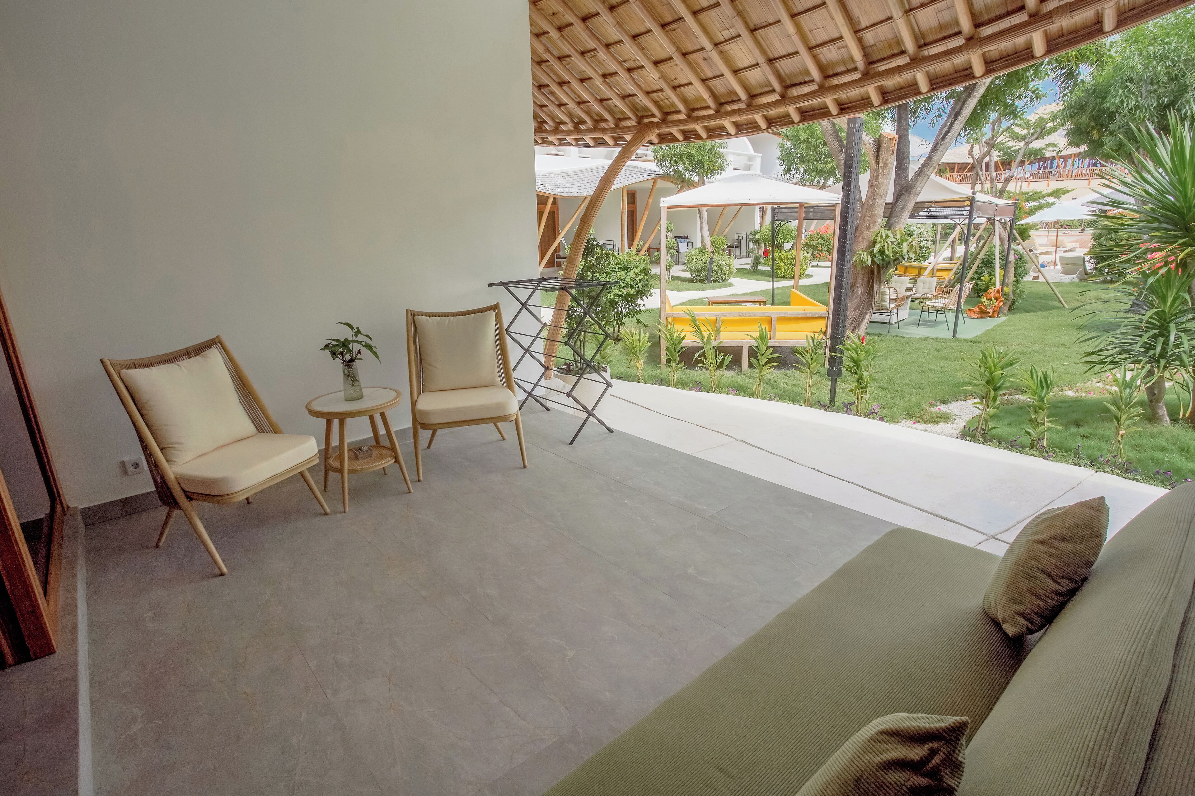A balcony with two chairs, a small table, and a sofa.