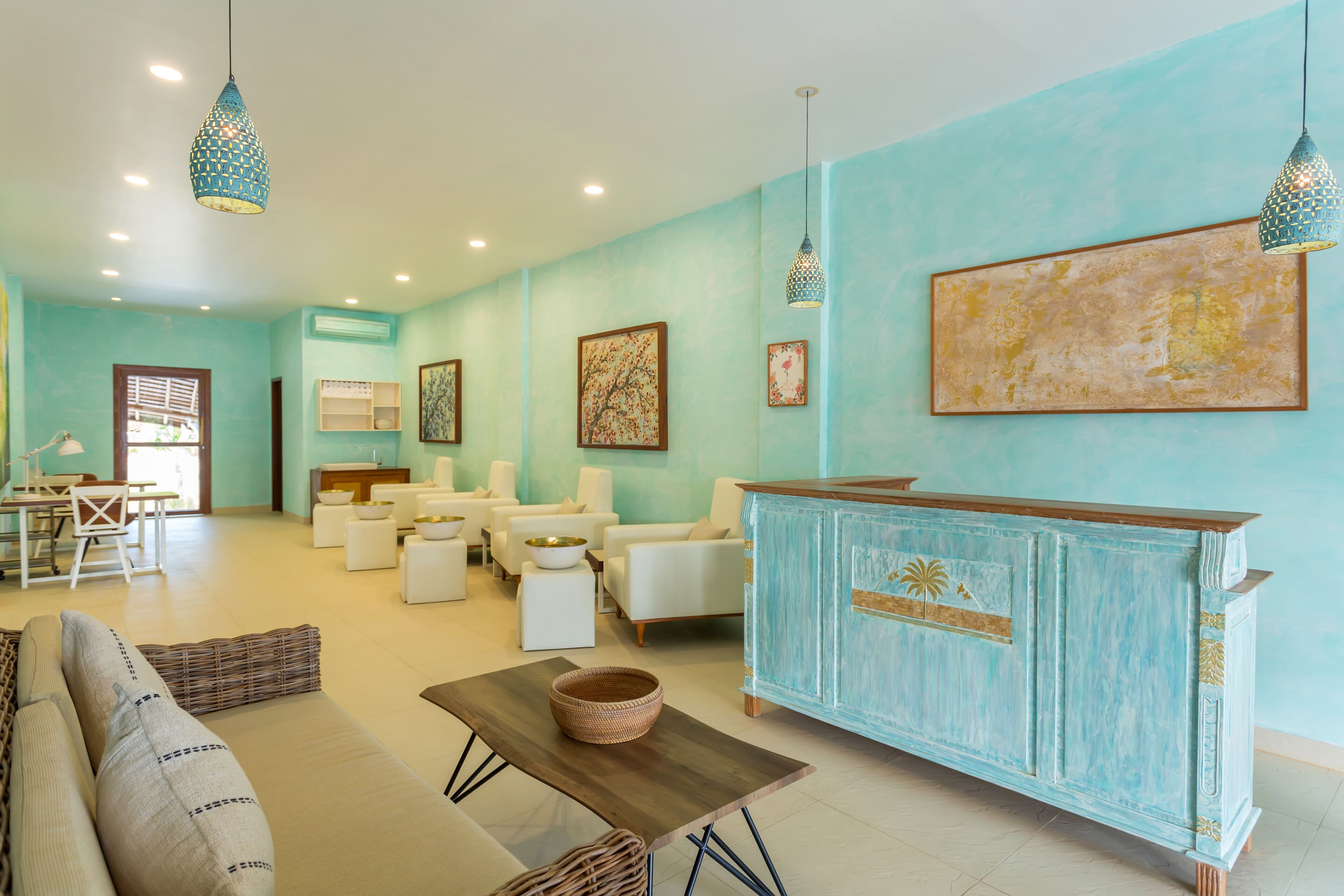 Un vaste espace de vie avec un mur bleu clair, des meubles blancs et une table basse en bois.