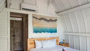 Un dormitorio con una cama de madera, aire acondicionado montado en la pared y un tapiz decorativo.