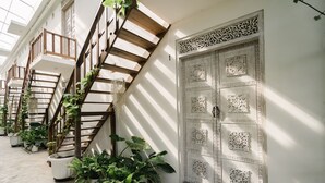 Un edificio con múltiples escaleras, plantas en macetas y puertas decoradas.