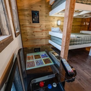 Ein gemütliches Blockhauszimmer mit Etagenbett, Bedienfeld und einem Poster an der Wand.