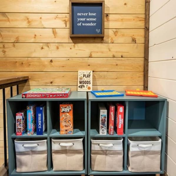 A bookshelf with board games and a sign that says "never lose your sense of wonder".