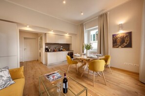 A modern apartment with a dining area, kitchen, and living space.