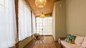 Una habitación acogedora con una mesa de madera, un sofá y una silla de mimbre.