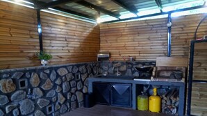 Eine rustikale Küche mit Holzwänden, einer Wand aus Stein und einem eingebauten Herd.