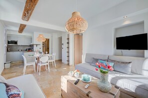 Un salon moderne avec un canapé, une table basse et un téléviseur fixé au mur.