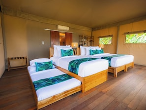 A room with two wooden beds, a wooden bench, a ceiling fan, and a window with a view of greenery. - Kaura Bali (Manggis)