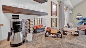 Une cuisine équipée d’une machine à café, de tasses à café et d’un panneau indiquant l’emplacement du coin café.