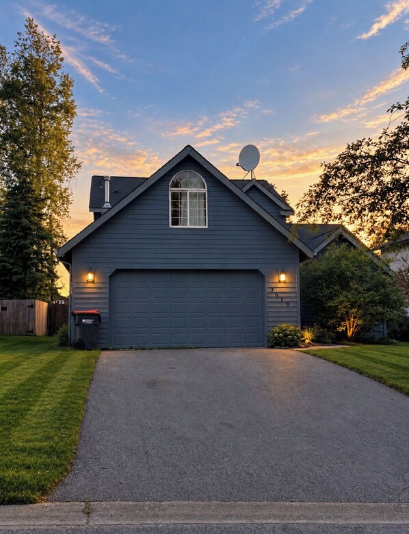A residential house with a garage, satellite dish, and a driveway. - Multi-Family House - Sleeps 16 (Anchorage)